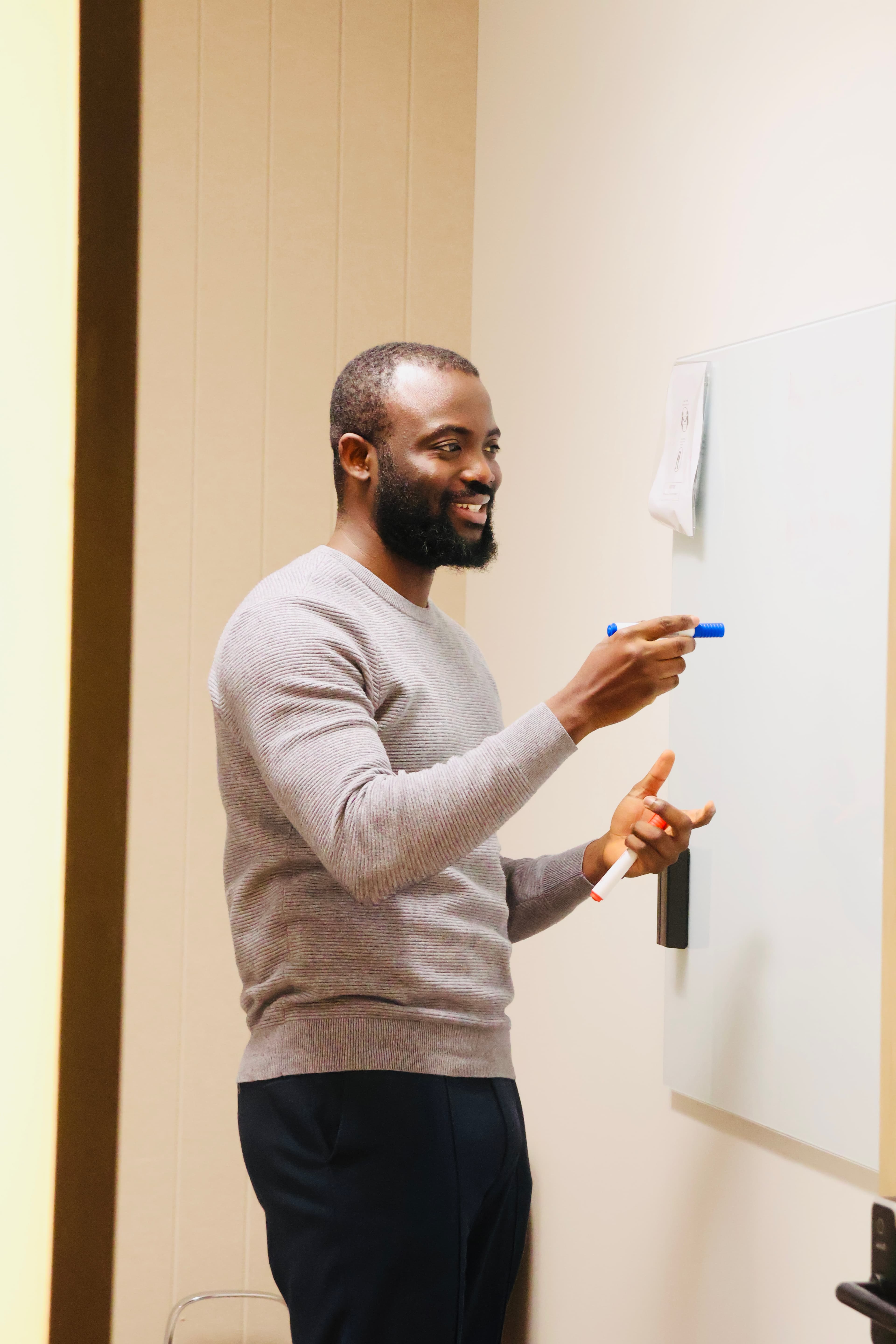 Noah Oloja teaching at a whiteboard