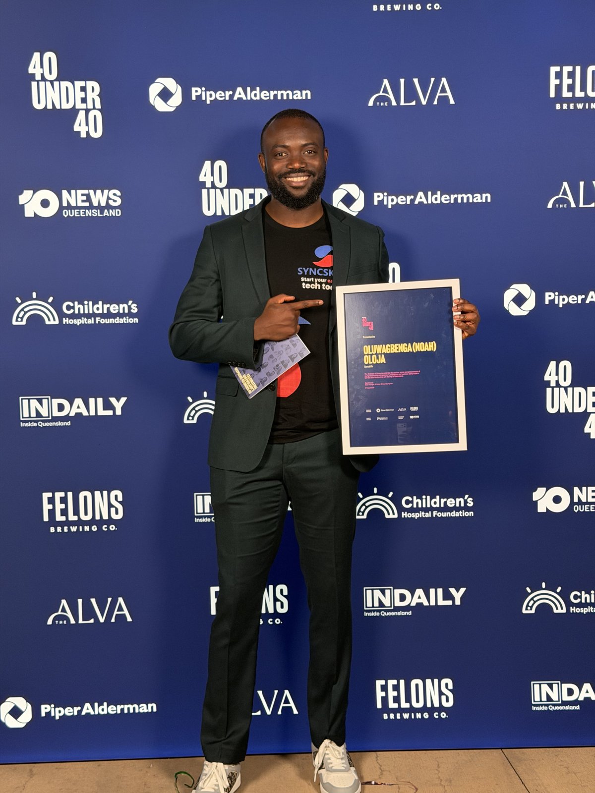 Noah holding his 40 Under 40 award