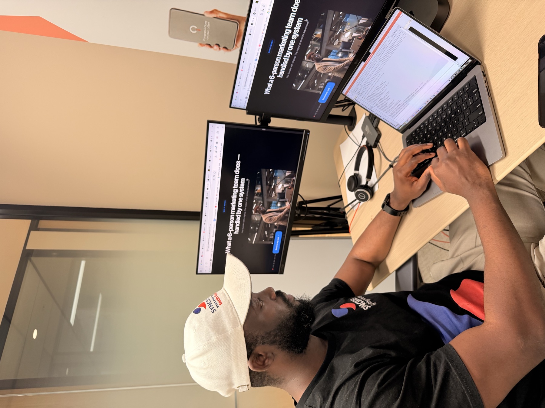 Noah at his desk with the system running on his screens